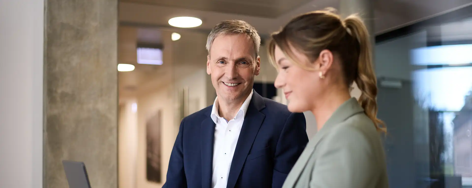 Eine Frau und ein Mann stehen an einem Tisch vor einem Laptop
