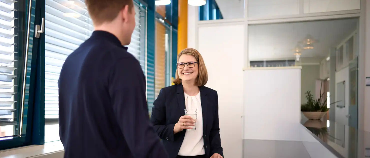 Zwei Personen stehen in der Küche und unterhalten sich