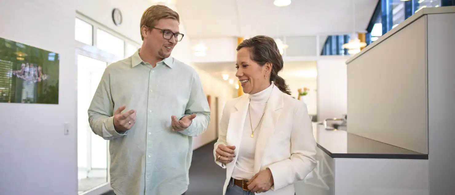 Zwei Personen laufen einen Flur entlang