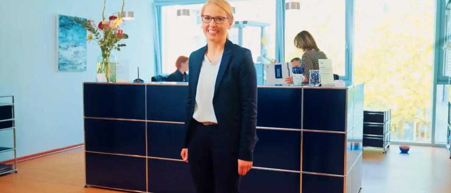 Eine Frau steht im Empfangsbereich einer Kanzlei