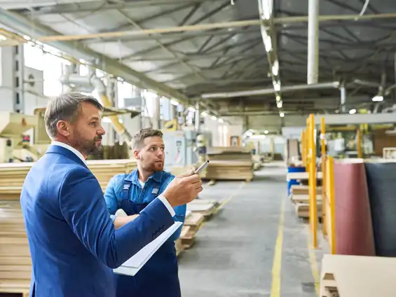 Zwei Männer stehen in einer großen Industriehalle